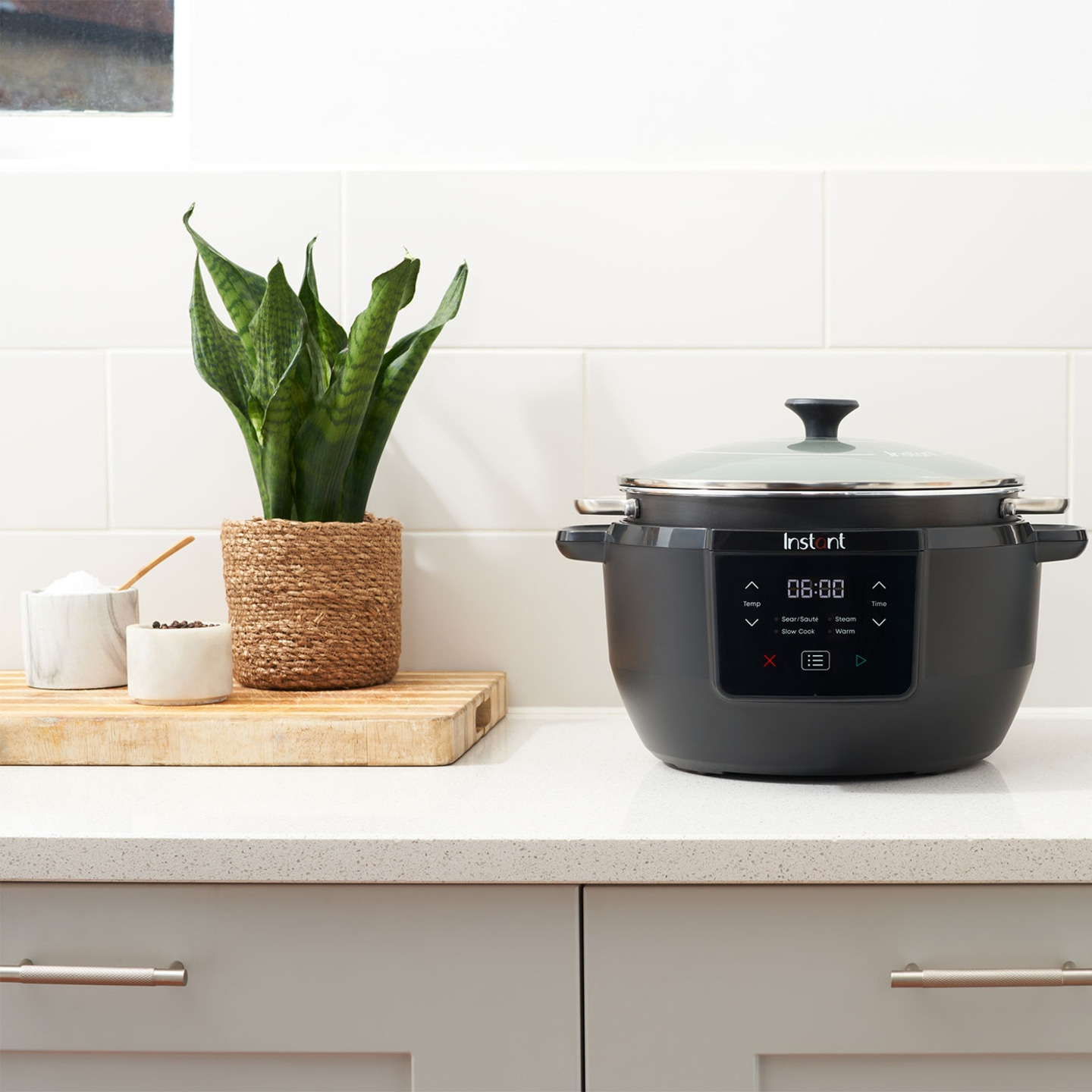 Instant Pot auf einer Küchenarbeitsplatte mit Pflanze und Gewürzen