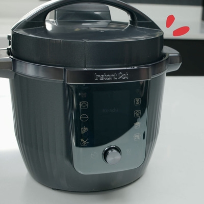 Instant Pot, ein elektrischer Schnellkochtopf, der auf einer weißen Oberfläche steht.