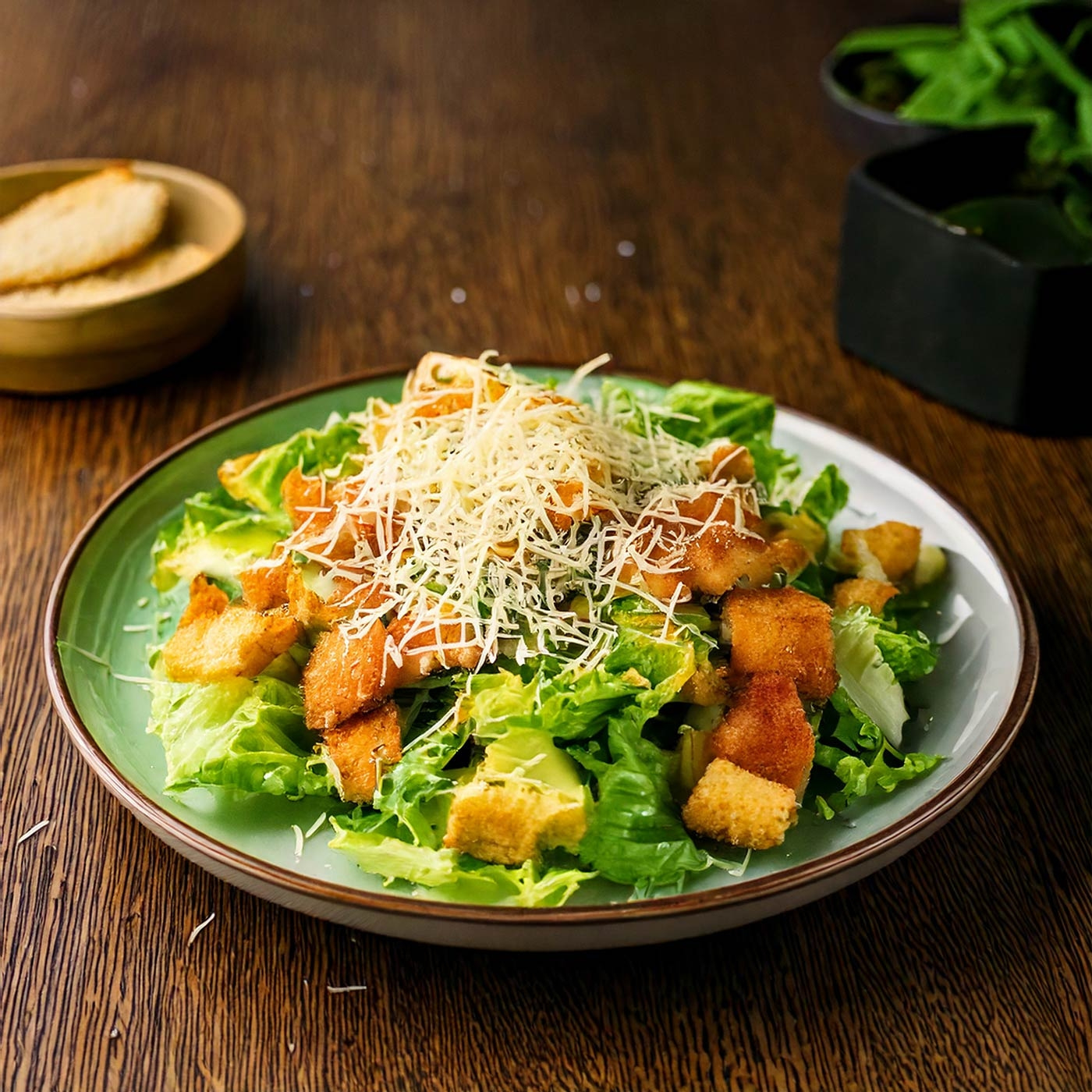 Nahaufnahme eines Salats mit Croutons, Käse und Dressing auf einem Teller