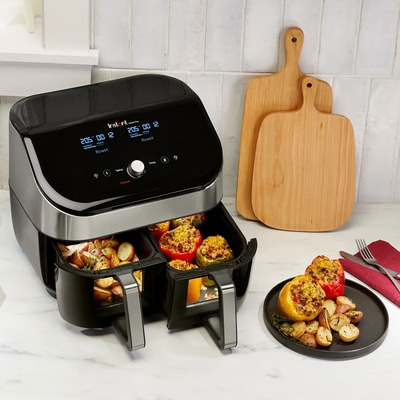Instant Vortex Plus Airfryer mit Gemüse und Schneidebrettern auf einer Arbeitsplatte