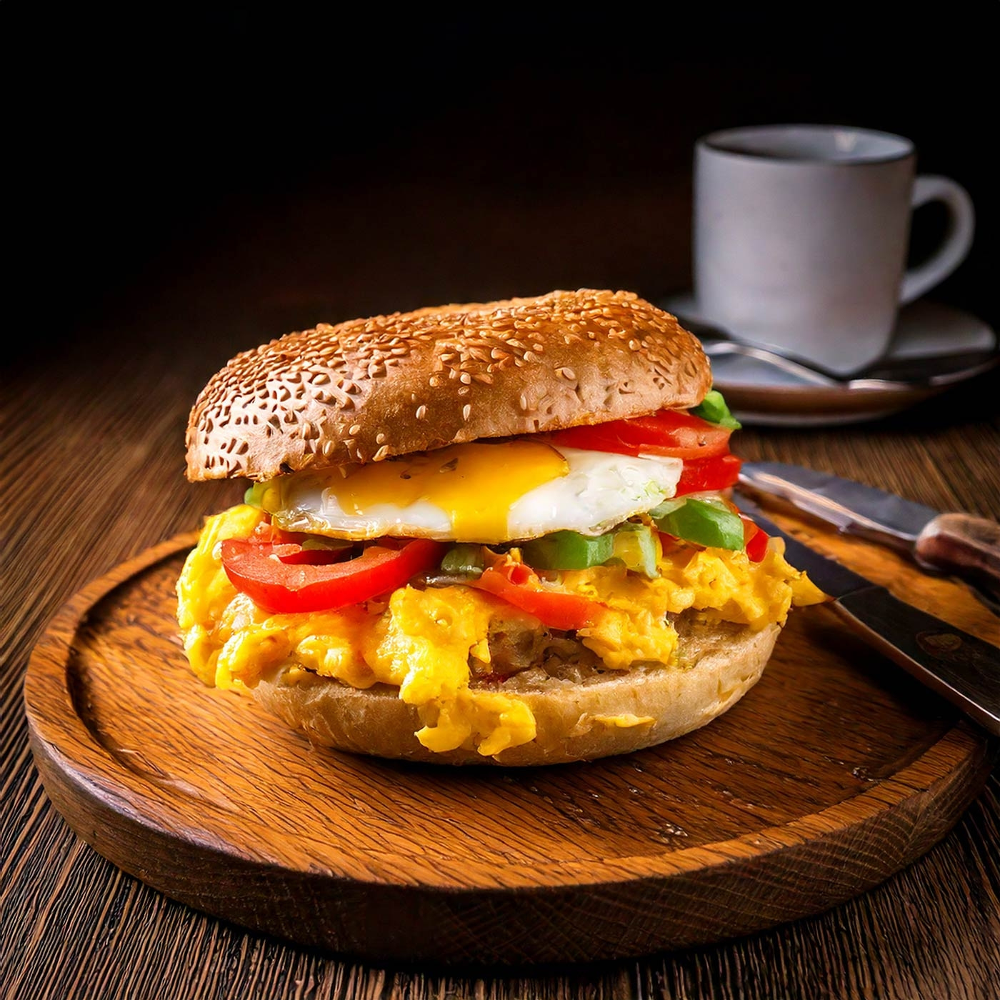 Frühstücks-Sandwich mit Spiegelei, Tomaten und Gemüse auf Holzbrett